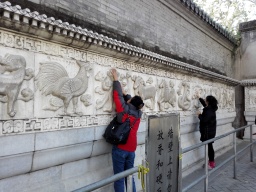 Visitors rubbing the carved zodiac signs on the screen walls, praying for good luck for themselves and their relatives.